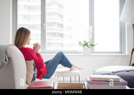 Young woman relaxing in living room Stock Photo
