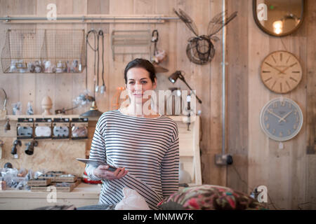 Portrait of small business owner holding digital tablet in a home store Stock Photo