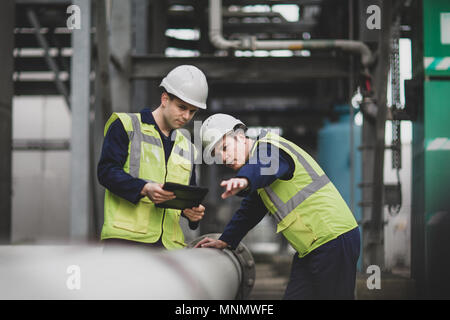 Industrial workers using a digital tablet on site Stock Photo