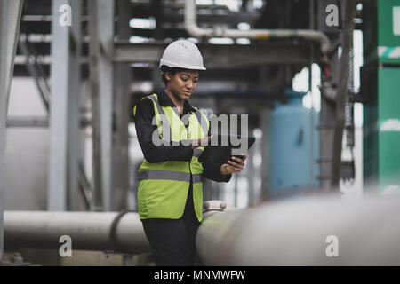 Female industrial worker checking pipeline Stock Photo