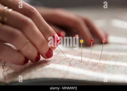 Woman applying pins on map Stock Photo