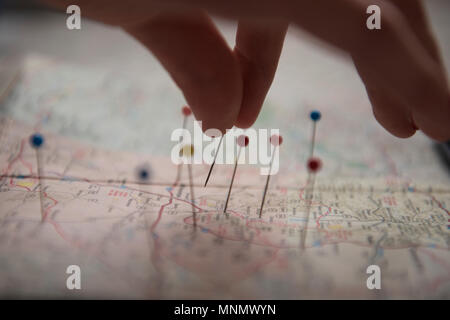 Woman applying pins on map Stock Photo