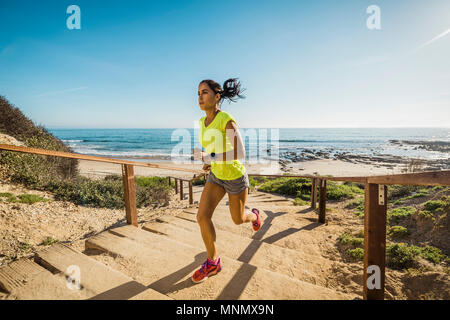 USA, California, Newport Beach, Woman running up stairs Stock Photo