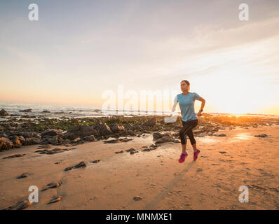 USA, California, Newport Beach, Woman running along beach Stock Photo