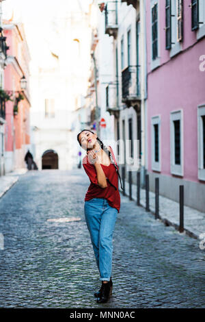 Portugal, Lisbon, Young woman blowing kiss in old town Stock Photo