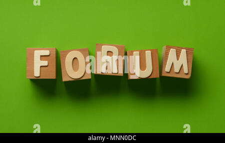 the word forum written on wooden cubes - green background - closeup Stock Photo