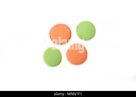 Orange and green macaroons isolated on white background Stock Photo