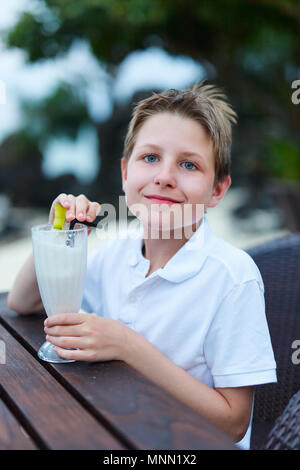 Teenage boy drinking milkshake in outdoor cafe Stock Photo