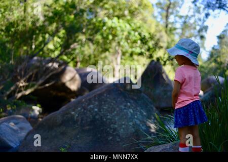 A child stands near some granite boulders, Jourama Falls, Bruce Hwy, Yuruga QLD, Australia Stock Photo