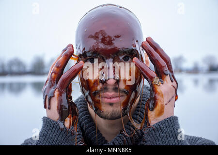 Portrait Of Man Covered With Brown Liquid Stock Photo