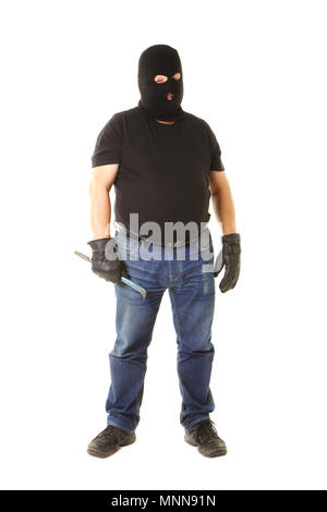 A standing person from the front with black t-shirt, blue jeans masked with a black balaklava holding a crowbar isolated against white background. Stock Photo