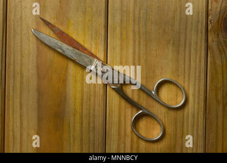 old scissors isolated on wooden background - closeup Stock Photo