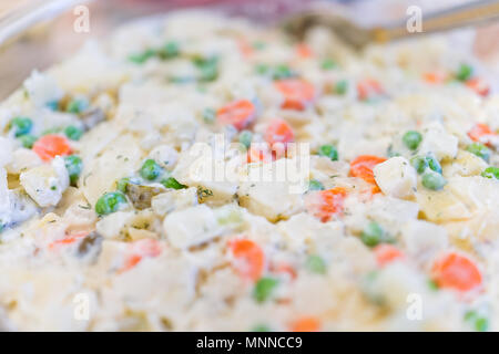 Traditional Ukrainian or Russian salad olivie, olivier macro closeup with potatoes, carrots, mayonnaise, peas, dill Stock Photo