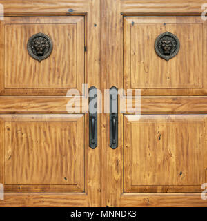 Close up detail of formal wooden front entry doors with bronze hardware. Exclusive, elegant, high quality, upscale, luxury house home real estate. Stock Photo