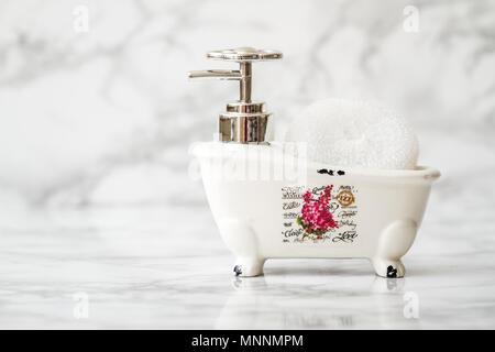 Decorative ceramic mini claw foot bathtub soap dish with bath sponge Stock Photo