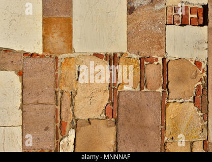 Old composite wall with stone blocks and briks as background Stock Photo