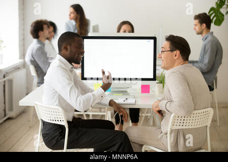 Friendly smiling diverse male colleagues having pleasant convers Stock Photo