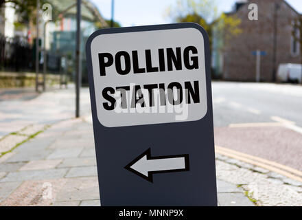 Polling Station sign with left pointing arrow on a typical British street. Stock Photo