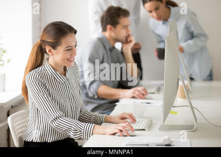 Beautiful smiling young businesswoman working on desktop compute Stock Photo