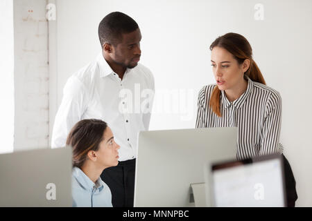 Serious multiracial team discussing solving business problem tog Stock Photo