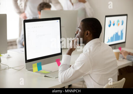 Serious african-american employee thinking over business email w Stock Photo