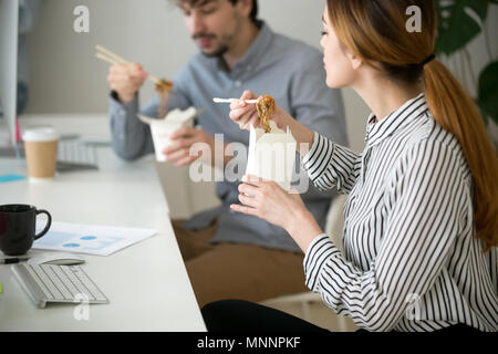 Office people eating chinese food in noodle box during lunch Stock Photo