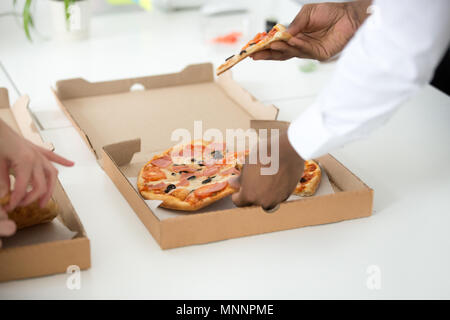 Hands of diverse people taking pizza slices, close up view Stock Photo