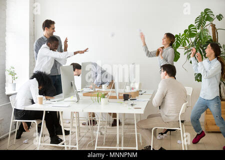 Happy multiracial team throwing crumpled paper balls having fun  Stock Photo