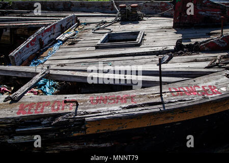 Warning Sign on a Rotting Wooden Structure of an old cargo  barge Stock Photo