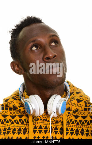 Face of thoughtful young black African man wearing headphones ar Stock Photo