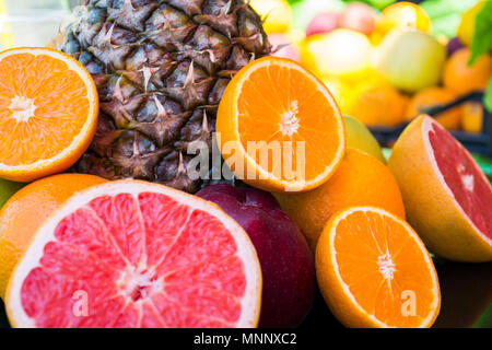 Cut and fresh fruits on green and yellow background Stock Photo
