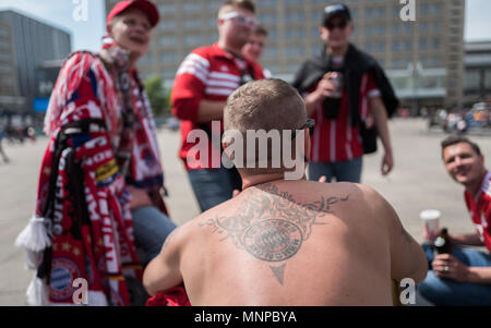 19 May 2018, Germany, Berlin: A fan of FC Bayern Munich with a Bayern Munich tattoo on his back spends his time at Alexanderplatz prior to the Deutscher Fußball-Bund (DFB) (lit. German Football Association) Cup's final match between FC Bayern Munich and Eintracht Frankfurt. The teams face each other at the Berlin Olympic stadium in the evening. Photo: Jörg Carstensen/dpa Stock Photo