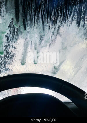 Car steering wheel with wash soap on windshield. Stock Photo