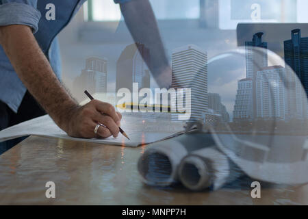 Enginee or architect  drawing and writing on plan paper on desk, architect and working concept ,mixed medai Stock Photo