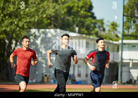 three asian young adults training running on track Stock Photo
