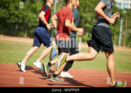 four asian young adults training running on track. Stock Photo