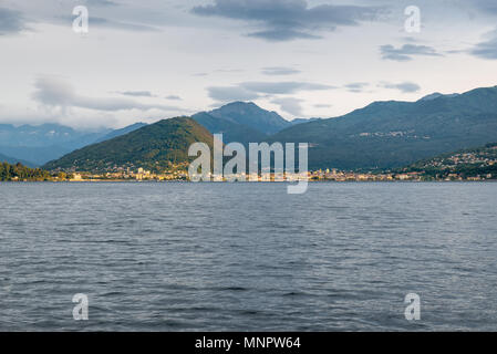 Lake Maggiore, Italy. Piedmont shore with the cities of Intra and Verbania at dawn, illuminated by the sun filtering through the clouds Stock Photo