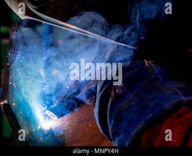 Man tig welding steel plates with brilliant bright white star burst bloom of lights Stock Photo