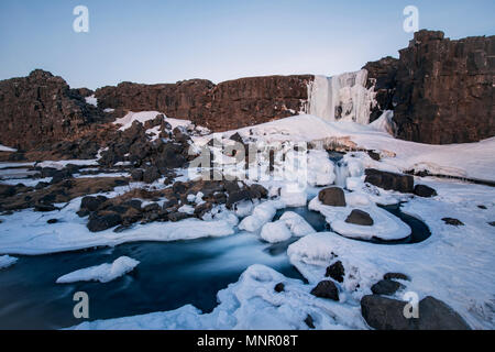 Partially frozen waterfall Öxarárfoss in winter, river Öxará, Pingvellir National Park, Golden Circle, South Iceland Stock Photo