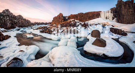 Partially frozen waterfall Öxarárfoss in winter, river Öxará, Pingvellir National Park, Golden Circle, South Iceland Stock Photo