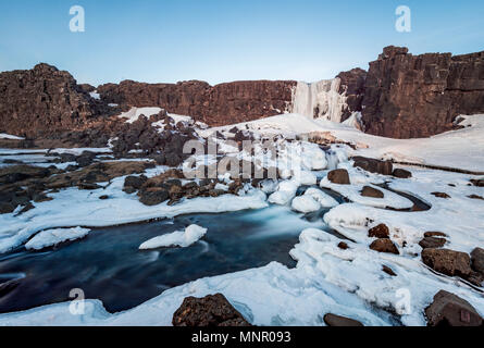 Partially frozen waterfall Öxarárfoss in winter, river Öxará, Pingvellir National Park, Golden Circle, South Iceland Stock Photo