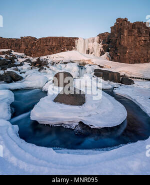 Partially frozen waterfall Öxarárfoss in winter, river Öxará, Pingvellir National Park, Golden Circle, South Iceland Stock Photo