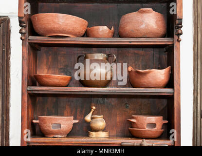 Old pottery pots, vases, jugs and pestle on the shelf Stock Photo