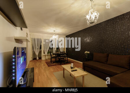 Interior scandinavian design of living room with chandeliers and white coffee table and brown sofa Stock Photo