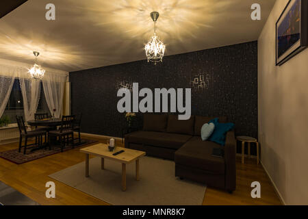 Interior scandinavian design of living room with chandeliers and white coffee table and brown sofa Stock Photo