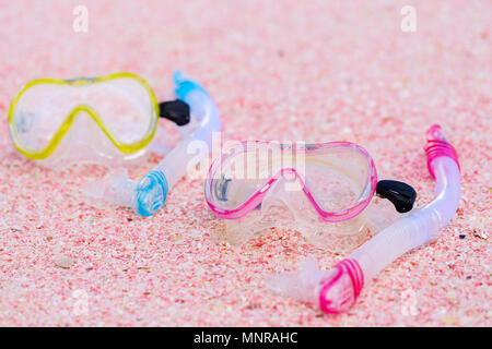Snorkeling equipment mask and snorkel on beach made of small pink shells Stock Photo