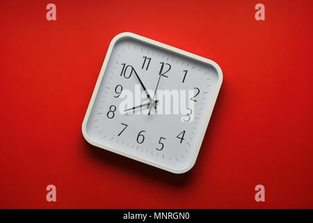 wall clock on the red background - closeup Stock Photo