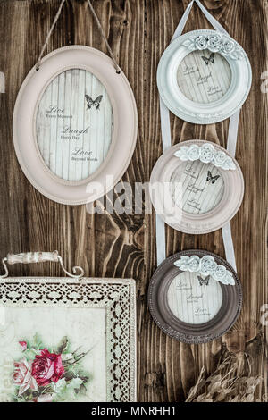 Picture frames with hanging ribbons on brown wooden background Stock Photo