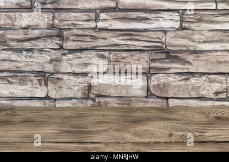 The background is a wall of large brown bricks and wooden boards. Stock Photo