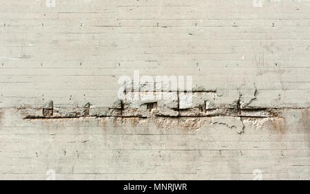 Background texture of dirty cement wall with large horizontal cracks and damage in middle. Stock Photo